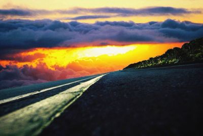 Surface level of road against dramatic sky