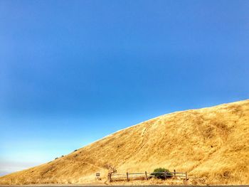 Scenic view of desert against clear blue sky