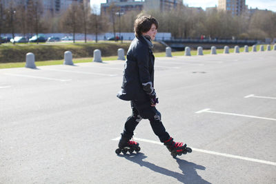 Full length of man skateboarding on road