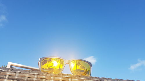 Low angle view of glass against blue sky