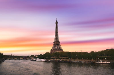 Tower in city against sky during sunset