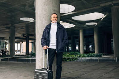 Senior man looking away while standing outdoors