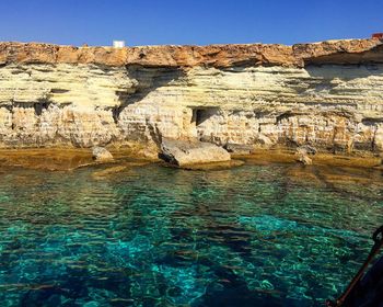 Rock formation in sea against sky