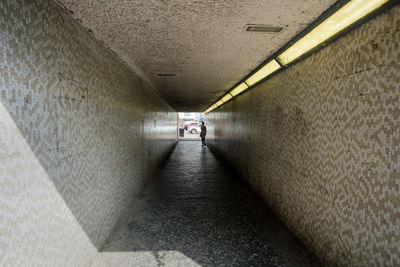 Man walking in illuminated tunnel