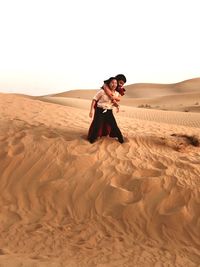 Female friends on desert against clear sky