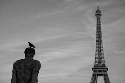 Low angle view of statue against tower