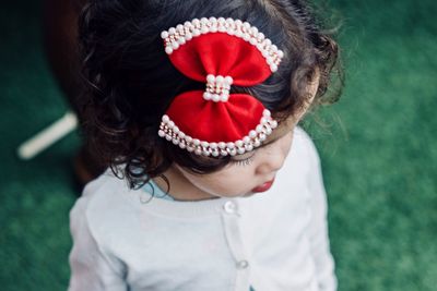 High angle view of girl wearing red bow on black hair