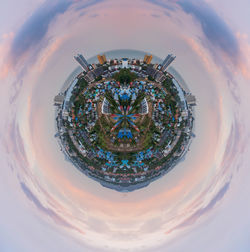 Digital composite image of buildings against cloudy sky