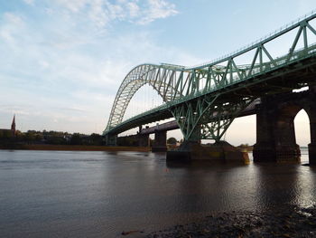 Low angle view of silver jubilee bridge over river against sky on sunny day