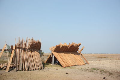 Planks hut on field against clear sky