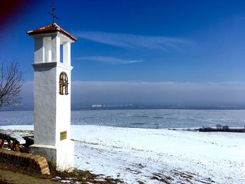 Bell tower by sea against sky