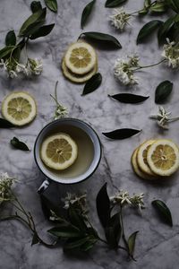 High angle view of lemon slices and leaves on table
