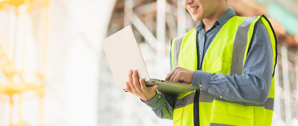 Midsection of woman working with mobile phone