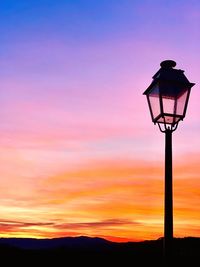 Low angle view of street light against orange sky