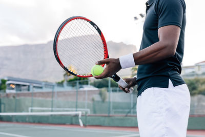 Midsection of man playing tennis