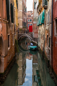 A small waterway on a quiet sunday morning with a small boat and laundry on the house facades.