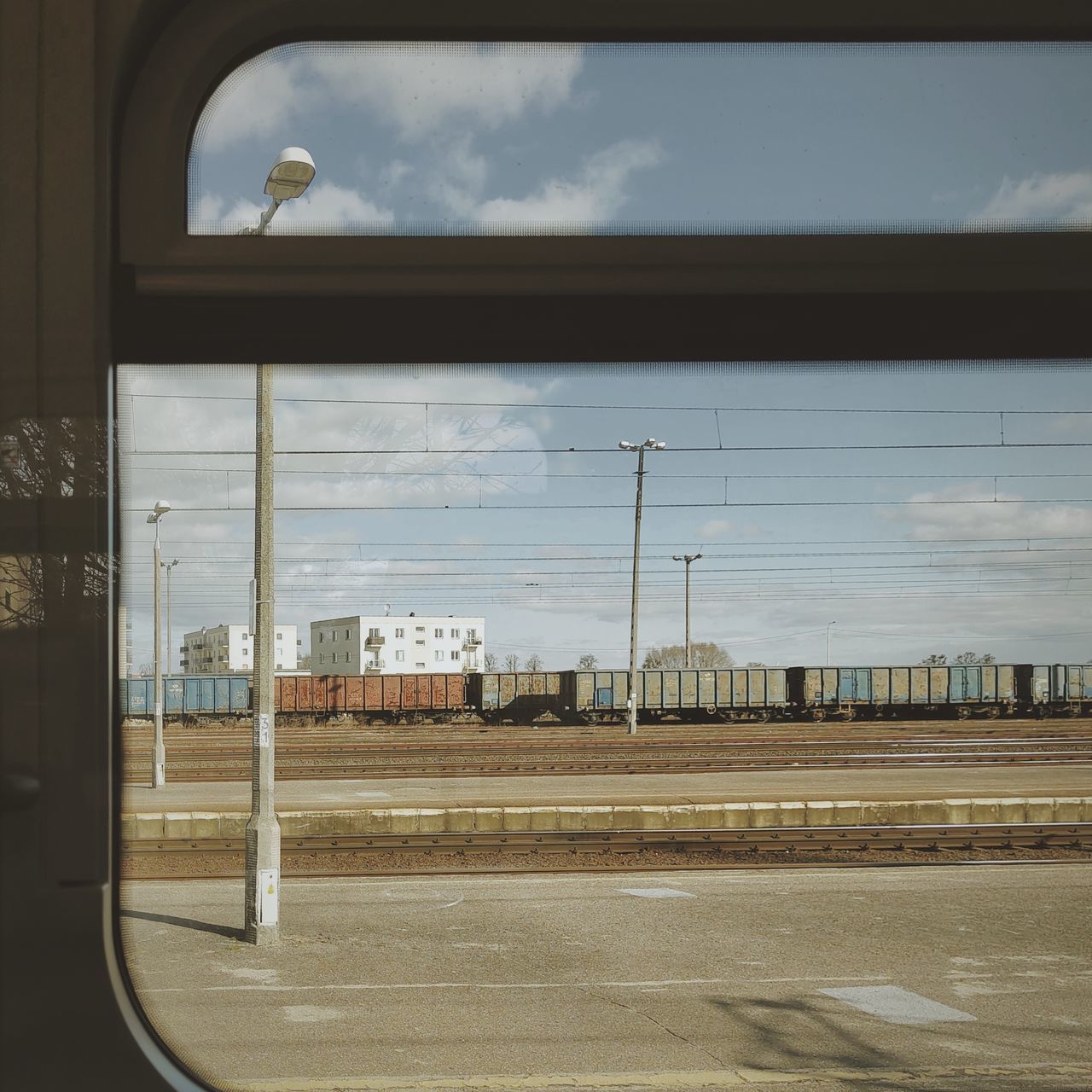 sky, cloud, transportation, architecture, window, day, no people, rail transportation, built structure, mode of transportation, nature, outdoors, glass, city, building exterior, transport, train, public transportation, travel, window covering, interior design, track, railroad track