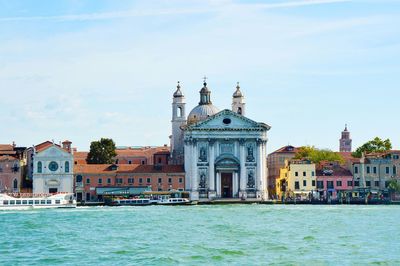 Church and river against cloudy sky