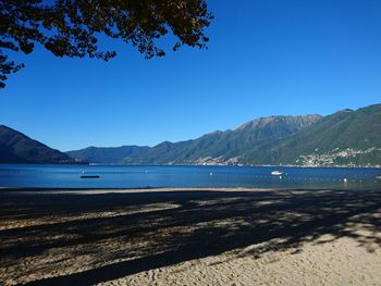 View of calm blue sea against mountain range
