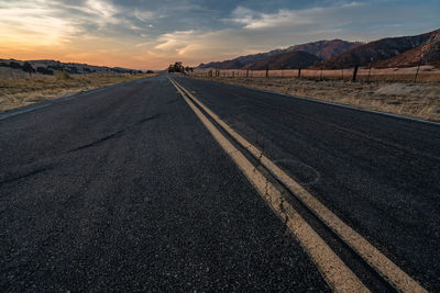 Empty road by mountain against sky