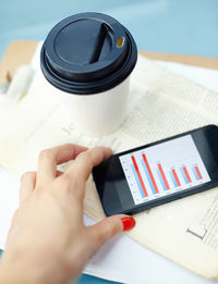 Cropped hands of woman using mobile phone