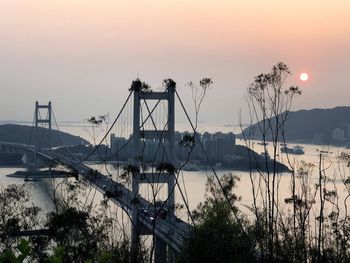 Tsing ma bridge over river against sky during sunset