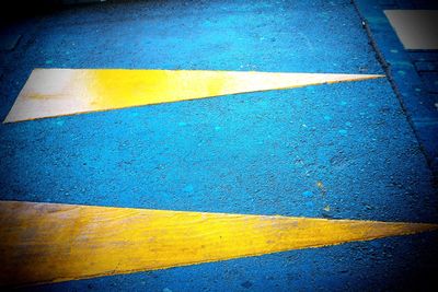 High angle view of yellow arrow symbol on road