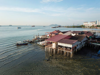 High angle view of city by sea against sky