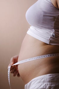 Close-up of pregnant woman measuring abdomen