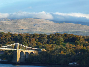 Arch bridge over river against sky