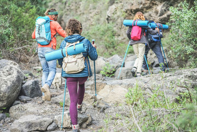 Rear view of people walking on rocks