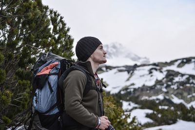 Man looking away against snowcapped mountains