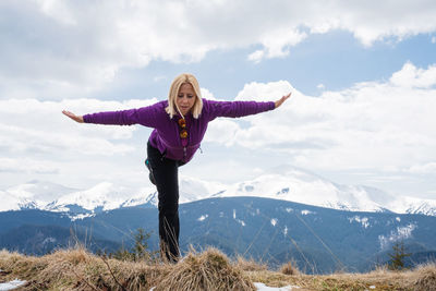 Full length of woman standing on mountain