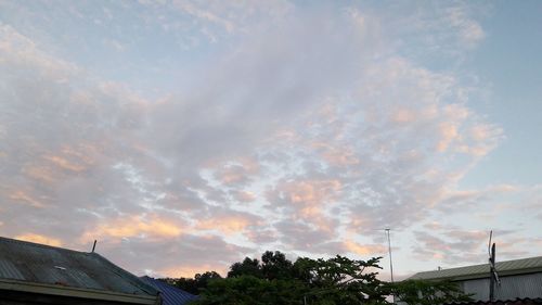 Low angle view of silhouette trees against dramatic sky