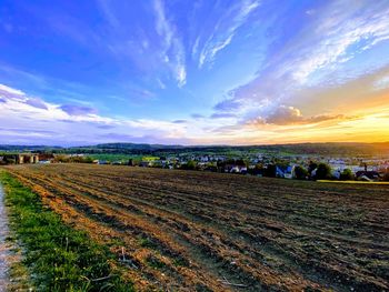 Scenic view of agricultural field against sky during sunset