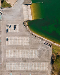 Directly above parking lot by sea in city