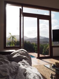 Landscape against sky seen through open door of house