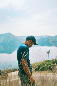 Young man on mountain against sky