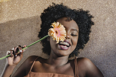 Portrait of smiling woman holding flowering plant