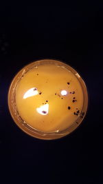Close-up of illuminated tea light bulb in darkroom