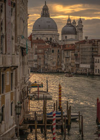 Grand canal amidst santa maria della salute and building against cloudy sky