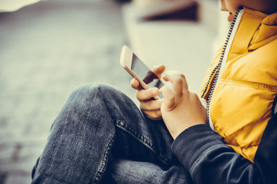 Midsection of man using mobile phone