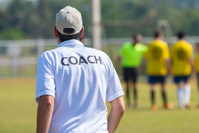 Rear view of man standing against blurred background