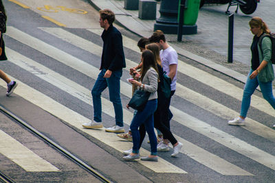 Rear view of people walking on city street