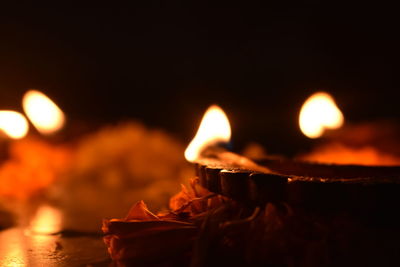 Close-up of burning candle against black background