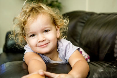 Portrait of smiling girl relaxing on sofa at home