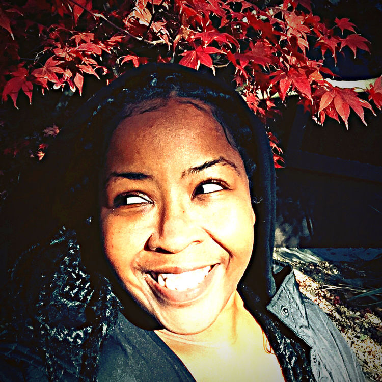 CLOSE-UP PORTRAIT OF SMILING WOMAN WITH LEAVES