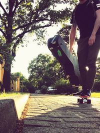 Low section of man skateboarding on road