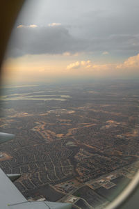 Aerial view of city against sky seen from airplane window