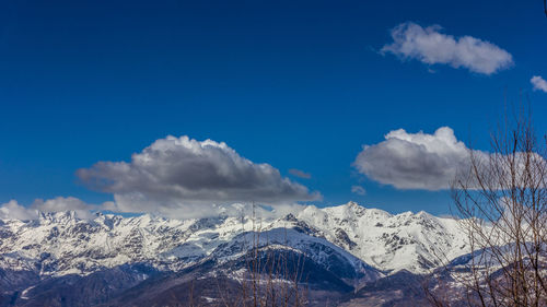 Scenic view of snowcapped mountains against blue sky